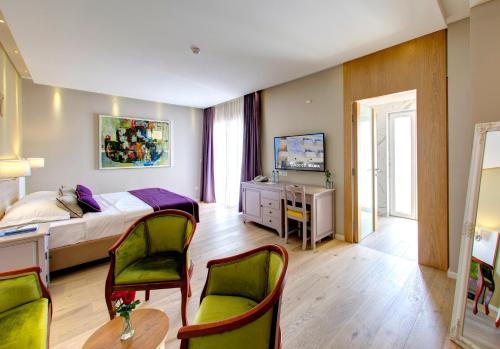 a bedroom with a bed and a table and chairs at Hotel Villa Regina in Međugorje