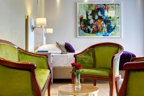 a room with two green chairs and a bed at Hotel Villa Regina in Međugorje