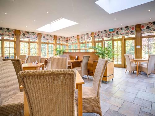 a restaurant with tables and chairs and windows at The Speech House in Coleford