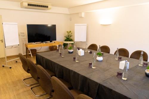 a conference room with a table and chairs and a screen at LUX* Grand Gaube Resort & Villas in Grand Gaube