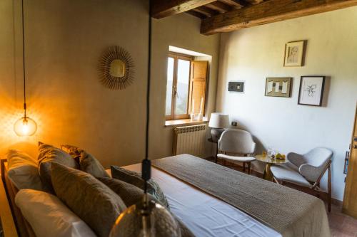 a bedroom with a couch and a table and a window at Borgo Castello Panicaglia in Nocera Umbra