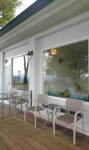 a porch with chairs and a table and a window at SunSweet House in Fanlu