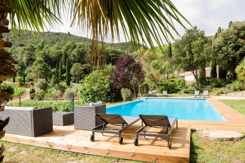 - une piscine avec 2 chaises sur une terrasse en bois à côté dans l'établissement Château Haut Gléon, à Villesèque-des-Corbières