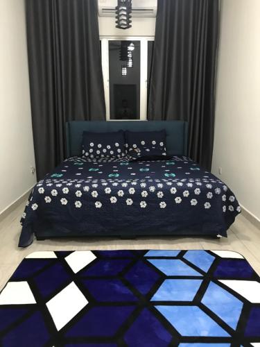 uma cama com um edredão azul num quarto em Wan Homestay Putra Impian em Kajang