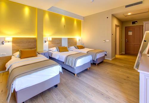 a hotel room with three beds in it at Hotel Villa Regina in Međugorje