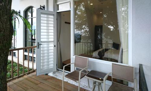 a balcony with two chairs and a sliding glass door at SunSweet House in Fanlu
