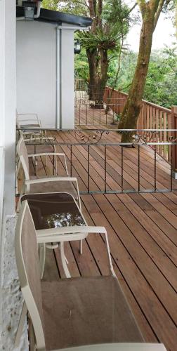 a wooden deck with two benches and a tree at SunSweet House in Fanlu