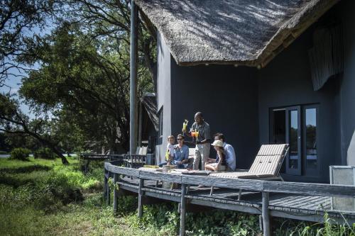 a group of people standing on the porch of a house at Simbavati River Lodge in Timbavati Game Reserve
