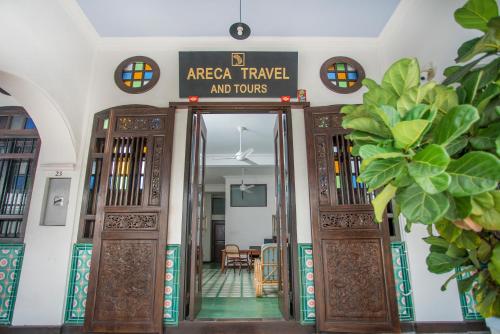 an entrance to a building with a sign that reads area travel and tours at Areca Hotel Penang in George Town
