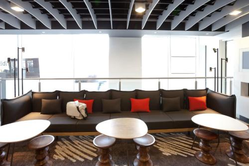 a living room with a couch and two tables at ibis Brighton City Centre - Station in Brighton & Hove