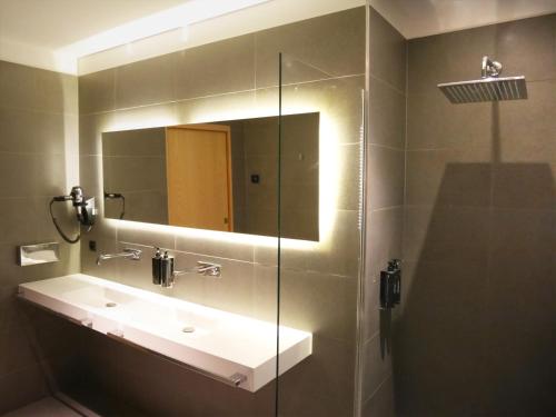 bagno con lavandino e specchio di Le Chat Qui Dort - Suites a Lille