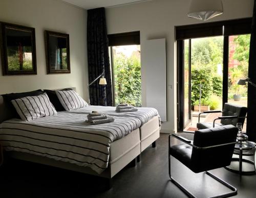 a bedroom with a bed and a chair and a window at Arthouse Dordrecht in Dordrecht
