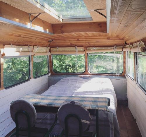 una cama en la parte trasera de una furgoneta con ventanas en Cosmic English Bus 2 floor en Mimizan