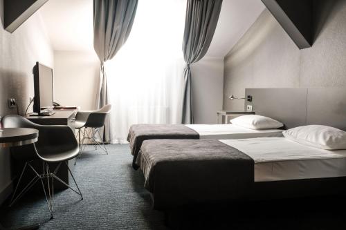 Pokój hotelowy z 2 łóżkami, biurkiem i komputerem w obiekcie Hotel Europa Starachowice w mieście Starachowice