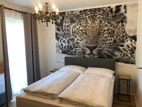 una cama con una foto de un leopardo en la pared en Enjoyit Velden West, en Selpritsch