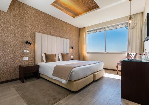 a bedroom with a large bed and a window at Lisotel - Hotel & Spa in Leiria