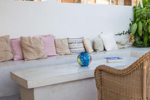 a bench with pillows and a vase on it at Evita in Faliraki