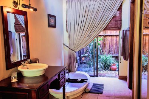 a bathroom with a sink and a mirror at Premier Resort Mpongo Private Game Reserve in Macleantown