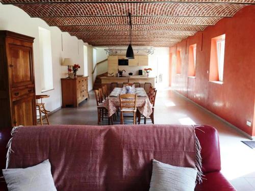 - un salon avec une table et une salle à manger dans l'établissement Florimont - Vaste gîte à la ferme, à Villers-Châtel