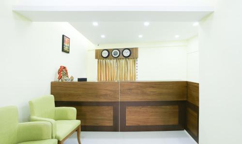 uma sala de espera com duas cadeiras e uma secretária em Treebo Trend The Galaxy Chandapura em Bangalore