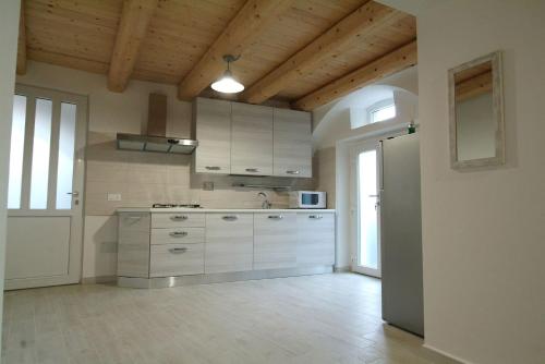 a large kitchen with white cabinets and a large window at La casa di nonno Enrico vicino alle Cinque Terre in Riccò del Golfo di Spezia
