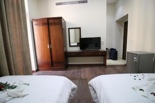 a hotel room with two beds and a television at Miramar Talaat Harb Square in Cairo