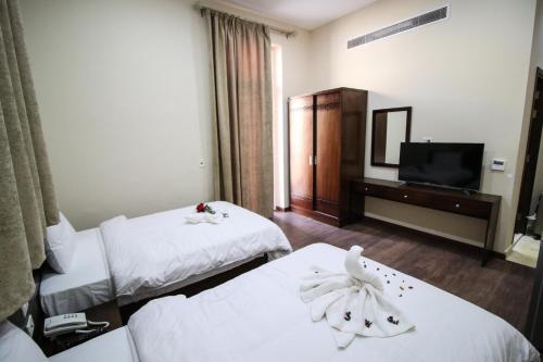 a hotel room with two beds and a television at Miramar Talaat Harb Square in Cairo