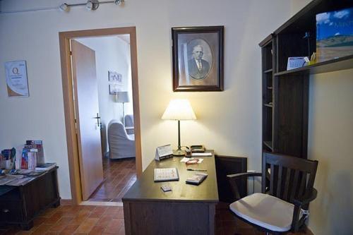 a office with a desk with a lamp and a chair at Antica Loggia in Fabriano