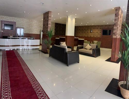 un vestíbulo con sofás y un bar en un hotel en منازل بجيلة للاجنحة الفندقية Manazel Begela Hotel Apartments, en Taif