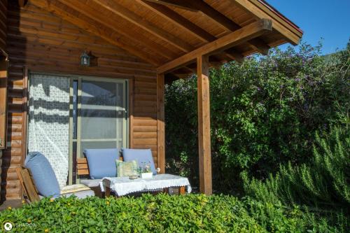 a porch of a cabin with a chair and a table at אניצ'ה in Had Nes