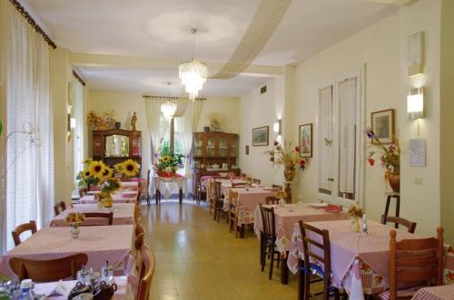 een eetkamer met tafels en stoelen met bloemen erop bij Albergo Ristorante Guidi in Pistoia
