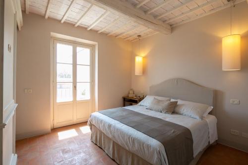 a bedroom with a bed and a large window at Villa Severina in Cortona