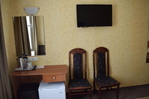 a room with two chairs and a desk and a television at Slavyanska Beseda Hotel in Sofia