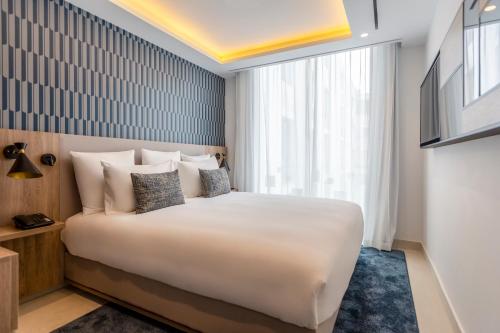 a bedroom with a large white bed and a window at Aparthotel Adagio Premium Casablanca City Center in Casablanca