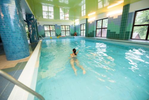 a person swimming in a swimming pool at Wierchomla Ski & Spa Resort in Piwniczna-Zdrój