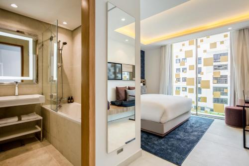 a bathroom with a tub and a bedroom with a bed at Aparthotel Adagio Premium Casablanca City Center in Casablanca