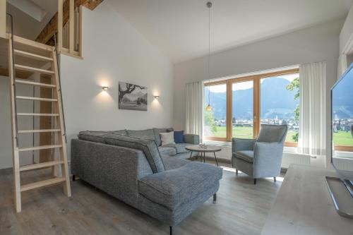 ein Wohnzimmer mit einem Sofa, Stühlen und einem Tisch in der Unterkunft Ferienwohnungen Alpentraum - Landhaus Gutermann in Oberstdorf