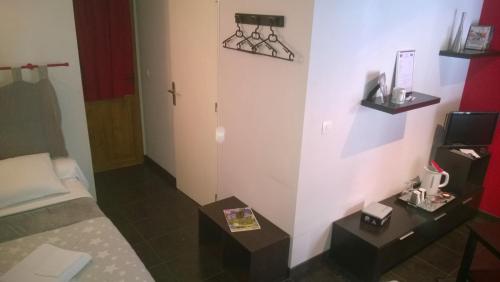 a small hotel room with a bed and a table at Chambres D'Hotes "Les Chiens Verts", jardin, terrasse, parking privé in Hauteville-Lompnes