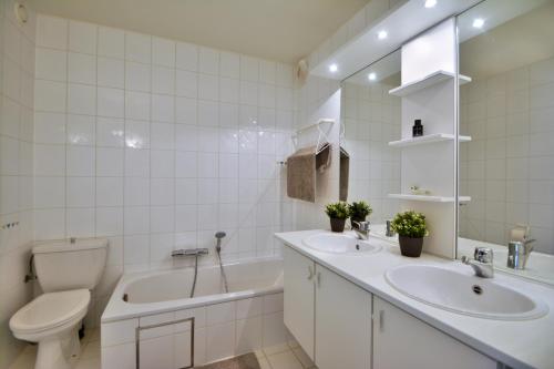 ein Badezimmer mit einem WC, einem Waschbecken und einer Badewanne in der Unterkunft Scorpio B in Nieuwpoort