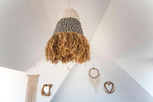 a bird nest hanging on a white wall with clocks at Bamboa Beachhouse in Zandvoort