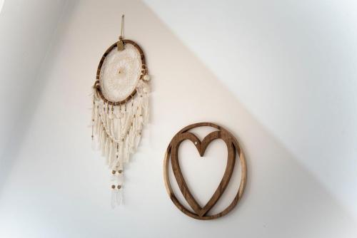 a heart shaped mirror and a clock hanging on a wall at Bamboa Beachhouse in Zandvoort