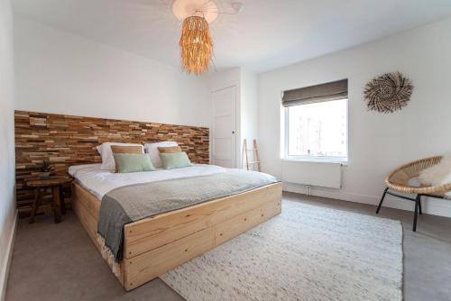 a bedroom with a bed and a brick wall at Bamboa Beachhouse in Zandvoort