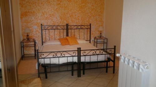 a bedroom with a bed with orange pillows on it at Agriturismo Francadu in Santu Lussurgiu