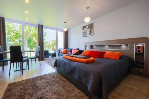 a bedroom with a large bed with orange pillows at Apartment Słoneczny Gródek 51 in Gródek Nad Dunajcem