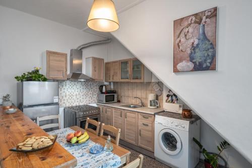 a kitchen with a wooden table and a kitchen with a refrigerator at The Junction Appartment in Agia Galini