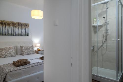 a bathroom with a bed and a glass shower at The Junction Appartment in Agia Galini