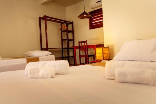- une chambre avec 2 lits et des draps blancs dans l'établissement Pousada Porto Azul, à Cumbuco