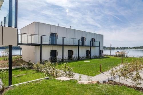 a large white building with a lake in the background at Golden Lakes Hotel in Boussu-lez-Walcourt