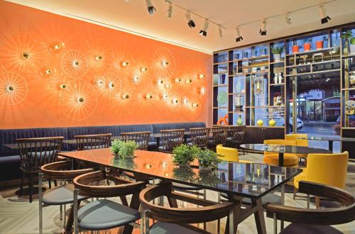 a dining room with tables and chairs and orange walls at Aparthotel Adagio Premium Casablanca City Center in Casablanca