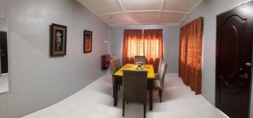 a dining room with a yellow table and chairs at Jitra homestay in Jitra